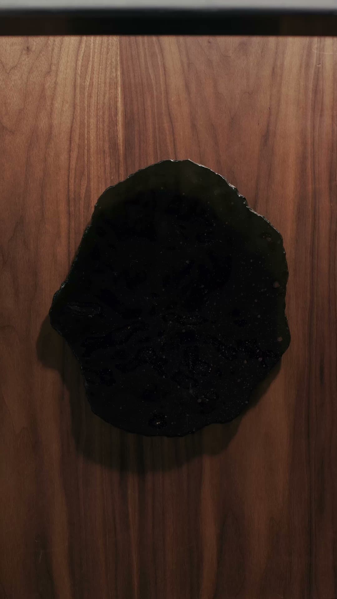 Assiette noire sur un plan de travail en bois, vue du dessus