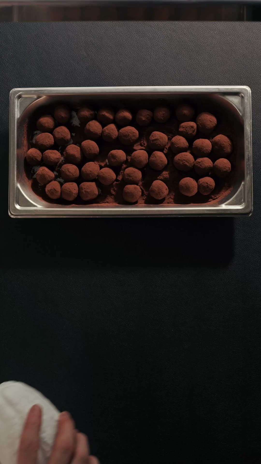 Plaque de truffes au cacao sur un plan de travail noir, vue du dessus